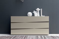 a white and grey dresser sitting on top of a carpeted floor next to a wall