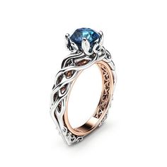 a ring with a blue stone in the center and intricate filigrees around it