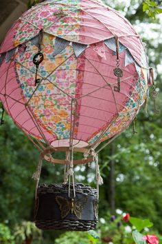 a pink hot air balloon hanging from a tree