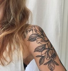 a woman with a flower tattoo on her arm