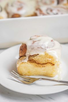 a piece of cinnamon roll on a plate with a fork