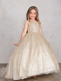 The Aurora Girls Glitter Tulle Dress is the epitome of fairytale elegance, perfect for making any young girl feel like a princess. Designed with a sparkling glitter tulle bodice and skirt, this dress catches the light with every twirl, creating a magical shimmering effect that is sure to captivate. The long, flowing train skirt adds a regal touch, making it an ideal choice for pageants, weddings, or any special occasion where making a grand entrance is a must. The large bow accent on the back se Glitter Ball Gown, Glitter Tulle Dress, Baby Christening Outfit, Girls Communion Dresses, Girls Ball Gown, Glitter Ball, Girls Pageant Dresses, Christening Dress, Communion Dresses