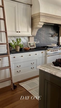 a kitchen with white cabinets and wooden ladder in the center, next to an oven