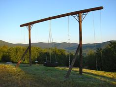 an empty swing set in the middle of a field