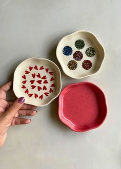 three bowls with different designs on them and one has a hand reaching for the bowl