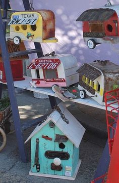 several bird houses are on display in front of a wall with other items hanging from it