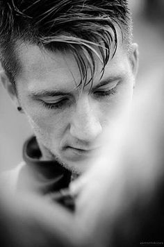 black and white photograph of a man with his eyes closed looking down at his cell phone