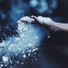 a person's hand is sprinkled with white powder