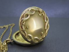 "Lovely antique locket set with an ornate design.  Opens and closes with a snap.  Nice and thick locket, well made. No frames/covers inside and some patina inside.  A little patina on the outside, some wear to the finish, and some very tiny dings.  Comes with a brand new 18\" gold plated stainless steel chain. All items added to your cart at Ribbons Edge will automatically combine shipping. To stay up to date with my newest offerings, follow me on IG @ RibbonsEdge" Circle Locket, Antique Locket, Ornate Design, Locket Necklace, Steel Chain, Stainless Steel Chain, Locket, Antique Jewelry, Gold Plate