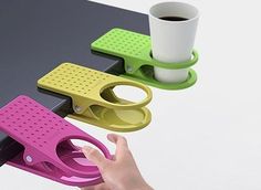 three different colored scissors are sitting on a table next to a cup and coffee mug