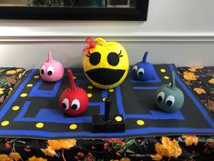 three different colored balls with eyes and noses sitting on a black table cloth next to a mirror