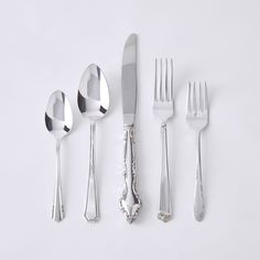 silverware is laid out on a white surface