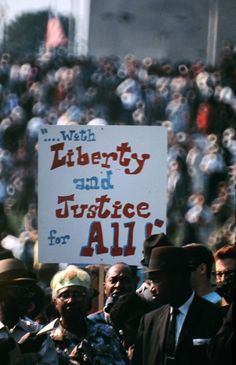 a group of people holding signs in front of a crowd