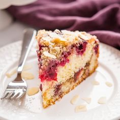 a piece of cake on a white plate with a fork and purple napkin in the background