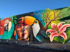 a large mural on the side of a building with birds and flowers painted on it