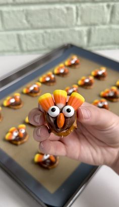 a hand holding a doughnut decorated like a turkey