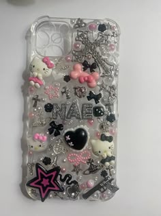 an iphone case with hello kitty charms on it