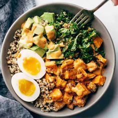 a bowl filled with rice, eggs and greens