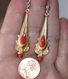 ANTIQUE GORGEOUS PAIR OF 14K GOLD HAND CARVED GENUINE UNDYED ITALIAN RED CORAL LEVERBACKS AND 42MM OLD STOCK GF ELONGATED ETRUSCAN DROPS GOOD SIZE EARRINGS LONG SIZE EARRINGS LENGTH OF DROPS 57 MM OR 2.5 INCHES DIAMETER OF UNDYED RED OX BLOOD CORALS AT WIDEST AREA: 11 MM X 5.5 MM FROM TOP TO BOTTOM INCLUDING EAR WIRES 57 MM OR 2.5 INCHES FLEUR DE LIS 14K LEVER BACK EARRINGS ARE CONNECTED TO BRIGHT ROSE TONE GF ELONGATED ETRUSCAN DESIGN DROPS TO CRETAE AN OUTSTADING TWO TONE MATCH. 14K SOLID GOLD Red Filigree 14k Gold Jewelry, Red 14k Gold Filigree Jewelry, Red Hallmarked Evening Jewelry, Red Victorian 14k Stamped Jewelry, Elegant Red Earrings For Ceremonial Occasions, Red Art Deco Jewelry For Formal Occasions, Collectible Red 14k Stamped Jewelry, Red Art Deco Hallmarked Jewelry, Elegant Red Jewelry For Collectors