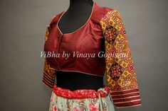 This Maroon blouse is hand-painted on raw silk and embellished with embroidery and Patola sleeves design. It provides a versatile style, perfect for mixing and matching with multiple sarees. Its 3/4th sleeves give this blouse a modern, sophisticated silhouette and style to your wardrobe this festive season. Designer Red Cotton Silk Choli, Red Cotton Silk Blouse Piece With Kalamkari Print, Red Unstitched Tussar Silk Blouse, Embroidered Red Cotton Silk Blouse Piece, Festive Tussar Silk Blouse With Kalamkari Print, Red Chanderi Blouse With Motifs, Traditional Red Cotton Silk Blouse, Red Cotton Silk Blouse With Cutdana, Red Tussar Silk Blouse With Zari Work