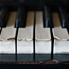 the keys of an old piano are black and silver