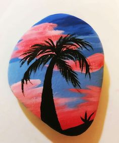 a painted rock with a palm tree on it