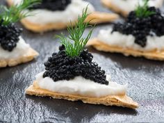 crackers topped with black cavia and dill sprinkled with white icing