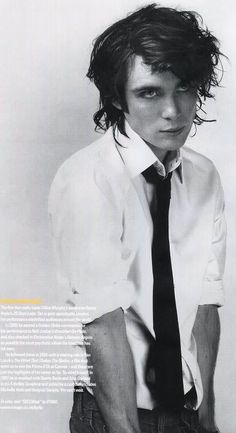 a young man with long hair wearing a shirt and tie posing for a magazine cover