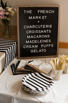 a table topped with french fries next to a sign