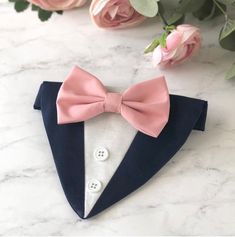 a pink bow tie on top of a blue suit