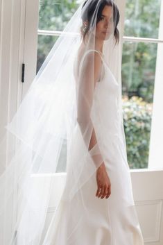 a woman in a white wedding dress and veil