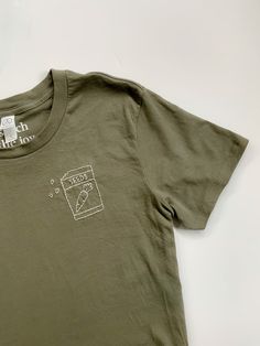 Is garden season your favorite season? Show off your garden love with our seed packet tee featuring a tiny carrot ready to plant. Hand stitched on a dark green women's relaxed fit shirt. SHIRTS 100% cotton jersey shirt Soft style, pre-shrunk Classic fit, recommend usual size Size guide available in images CARE Recommend washing cold on a gentle cycle. Hang dry. PRODUCTION Each item is handmade and made to order, so no two items will look the same. All items are hand embroidered using 100% DMC cotton thread. --MORE ITEMS-- My Etsy Shop: https://www.etsy.com/shop/StitchTheJoy Personalized Unisex Tees: https://www.etsy.com/listing/801014473/custom-hand-embroidered-shirt?ref=shop_home_active_25&frs=1&crt=1 Thank you for supporting handmade! Follow me on Instagram @stitchthejoy to see my latest Olive Green T Shirt, Botanical Embroidery, Embroidery Hand, Embroidered Tee, Seed Packets, Embroidered Clothes, Favorite Season, Green Tshirt, Embroidered Tshirt