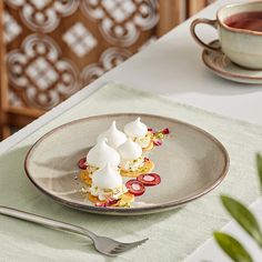 some food is on a plate near a cup and saucer