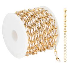 a spool of gold chain next to a spool of white thread on a white background