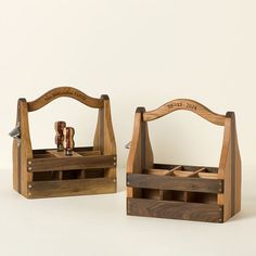 two wooden containers with bottles in them sitting next to each other on a white surface