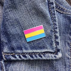 a pin with a flag on it in the back pocket of a jean jacket,