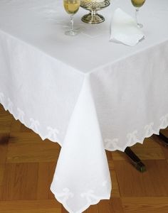 two glasses of wine sit on top of a white table cloth with lace edging the edges