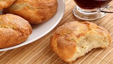 muffins on a plate next to a cup of tea