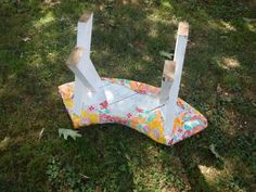 a broken chair sitting on top of a lush green field