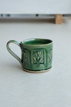 a green mug sitting on top of a white counter