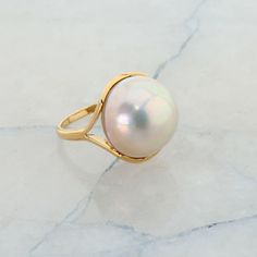 18K Yellow Gold and Pearl Ring, 16mm Moby pearl, Ring size 5.25, 7.2 grams Stock # R00036 This listing contains photographs of the actual item you will receive.  Our items are in excellent condition with little or no signs of wear and many are one of a kind pre-owned estate finds.   Please look closely at the pictures in this listing as they are part of the product description. Please read the description, as any imperfections or condition comments will be included.  We do our best to accurately describe the condition of each piece and encourage you to ask questions prior to purchase.    We are happy to address any questions you may have.  Please contact us.  Our Store has many other items for sale.  We specialize in fine & designer jewelry, watches & more.    Colonial Trading Company Than Heirloom High Luster Round Pearl Ring, Free Sign, Fine Jewelry Designers, Trading Company, Pearl Size, Pearl Ring, Designer Jewelry, Items For Sale, Jewelry Watches