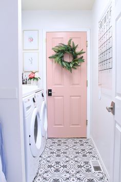 a pink front door with a wreath on it and a white washer in the foreground