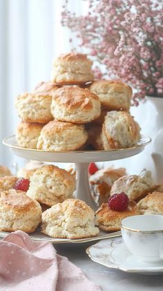 there are many different types of biscuits on the table and in front of some tea cups