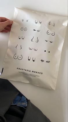 someone holding up a bag with faces drawn on it