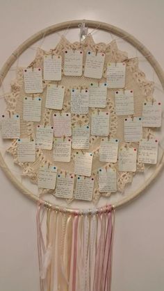 a dream catcher with lots of notes attached to it