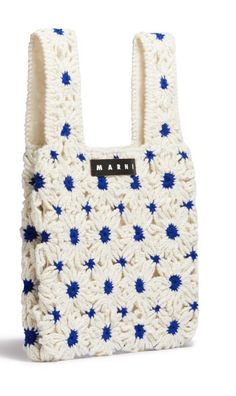 a crocheted bag with blue and white flowers on the front, sitting against a white background