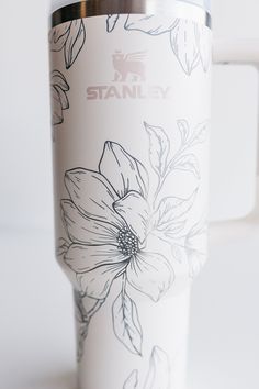 a white coffee cup with flowers painted on it