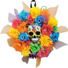 a skull with colorful flowers on it's head is hanging from a wall ornament