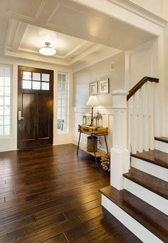 a foyer with wood floors and white walls