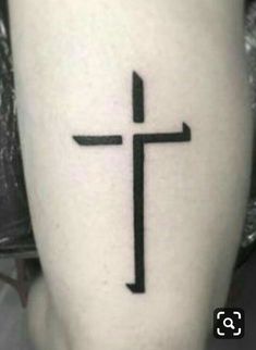 a black and white photo of a cross on someone's leg with the word jesus written in it